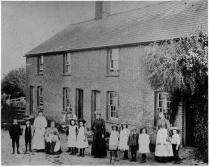 Old picture of people standing outside house